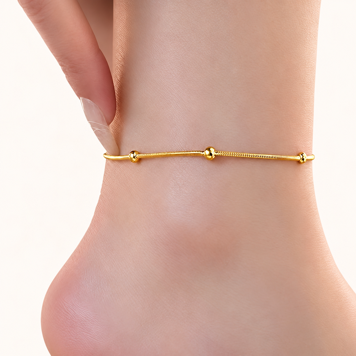 Golden ball chain anklet worn on ankle